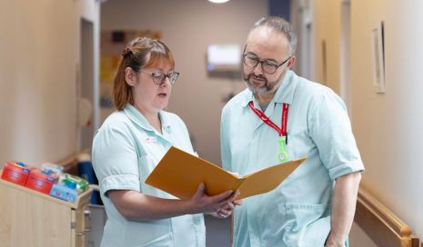 Purpose & Values Integrity SJH two HCAs talking with notes in corridor